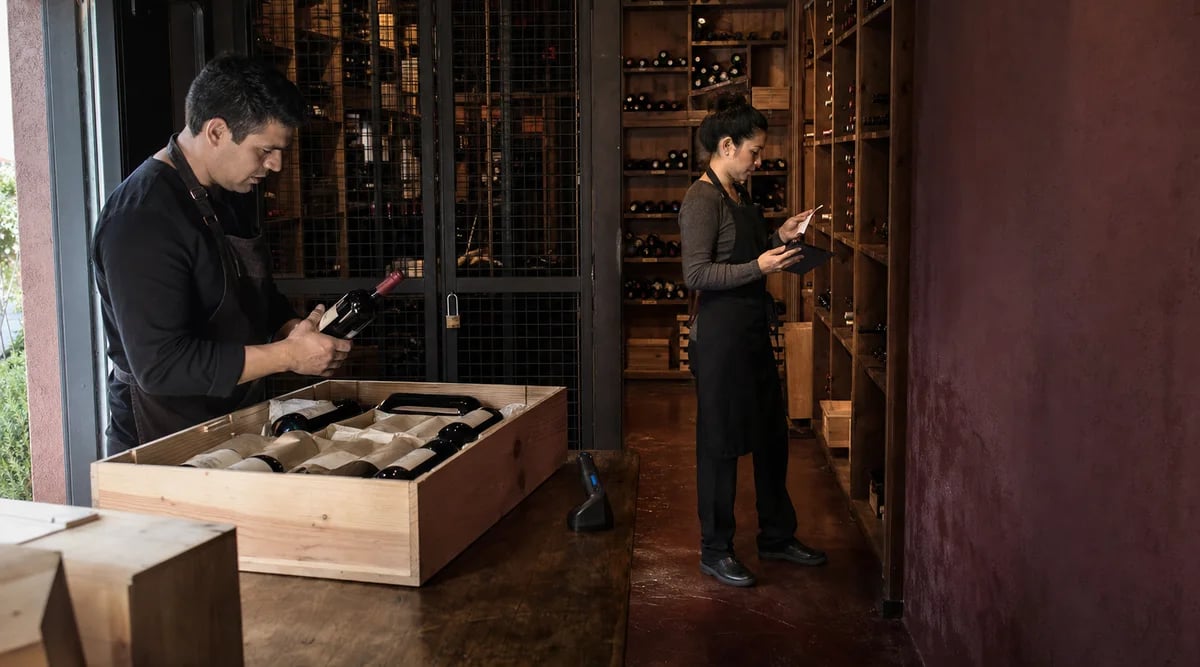 Dos responsables separan la recepción física y la verificación de una entrega de vinos
