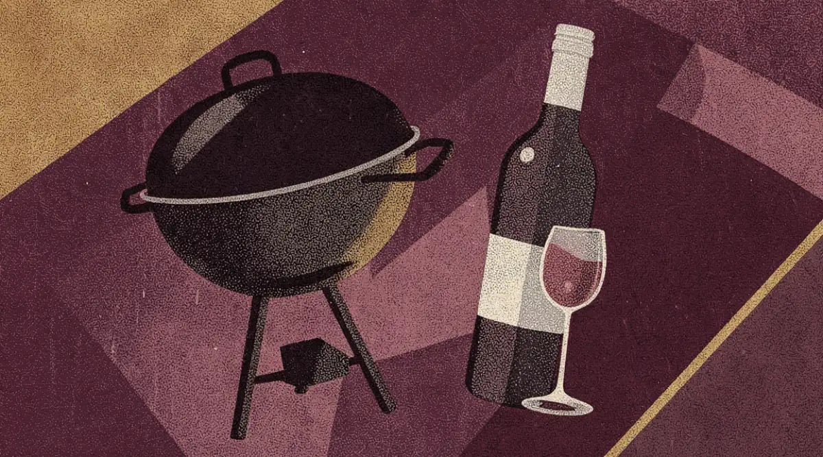 Copa de vino tinto junto a carne asada y costillas en parrilla con brasas encendidas