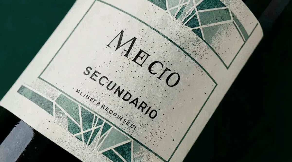 Subasta de vinos finos con botellas de Burdeos y Borgoña en sala iluminada